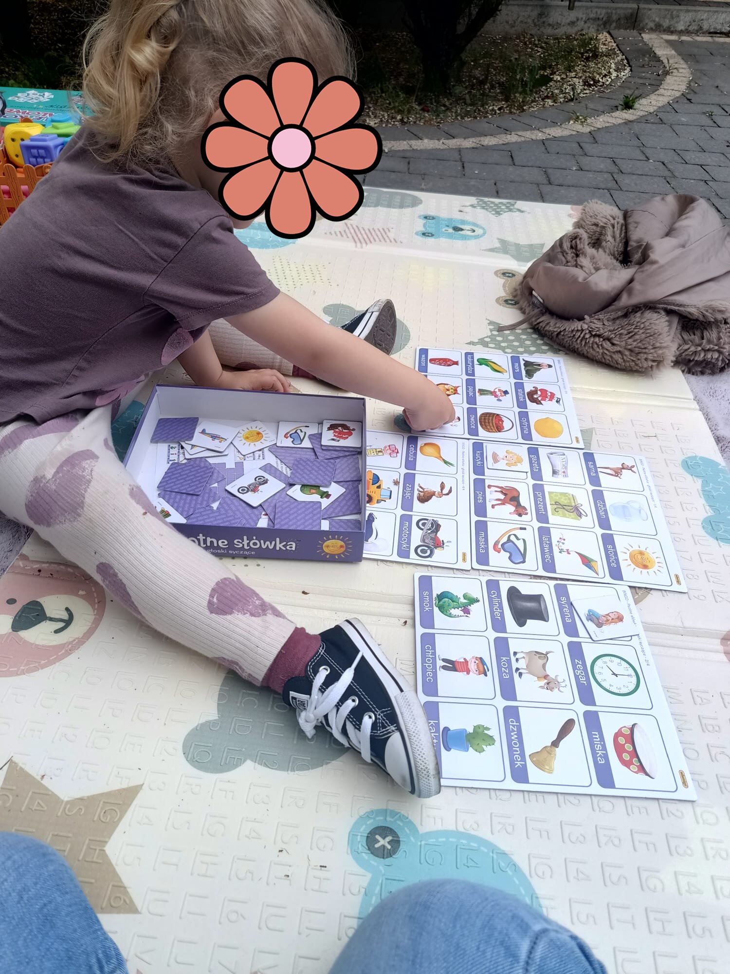 Dziewczynka układająca karty bingo z nazwami głosek